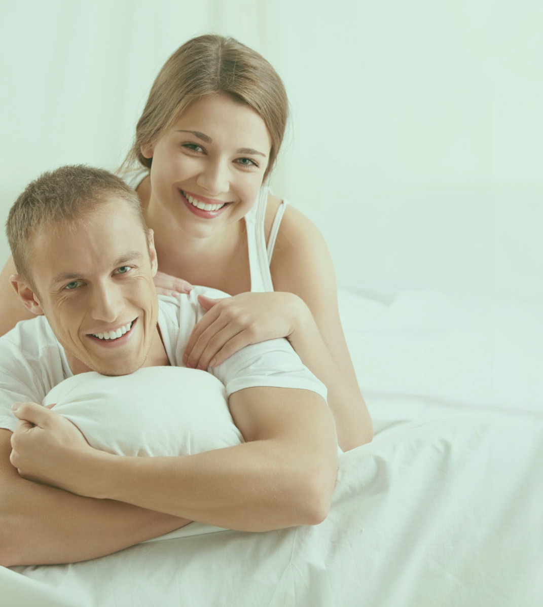 Happy relaxed young couple together in bed