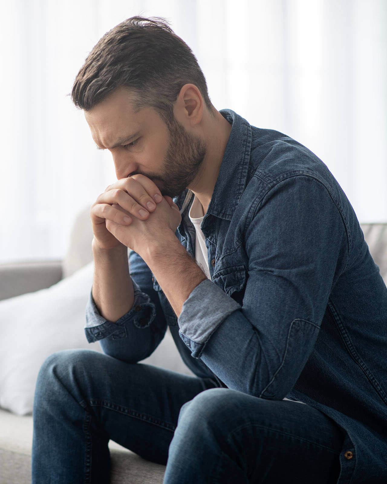 Sad man at home on sofa